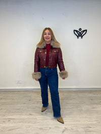 Cazadora corta de polipiel con pelo en el cuello y puño burdeos