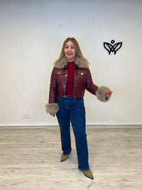 Cazadora corta de polipiel con pelo en el cuello y puño burdeos