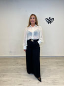 Pantalón palazzo negro con hebilla dorada y caída fluida