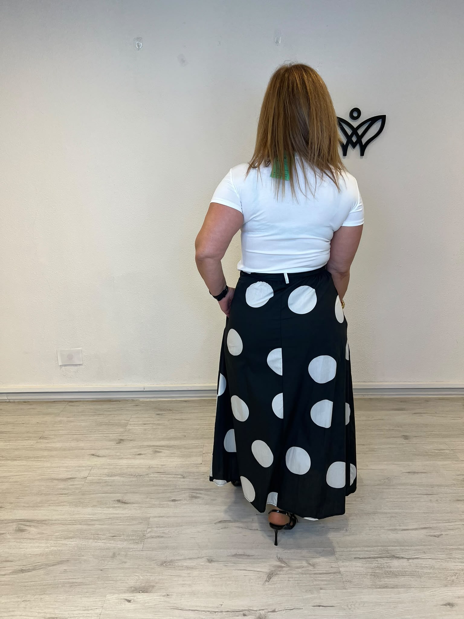 Falda negra con lunares blancos y bolsillos corte midi