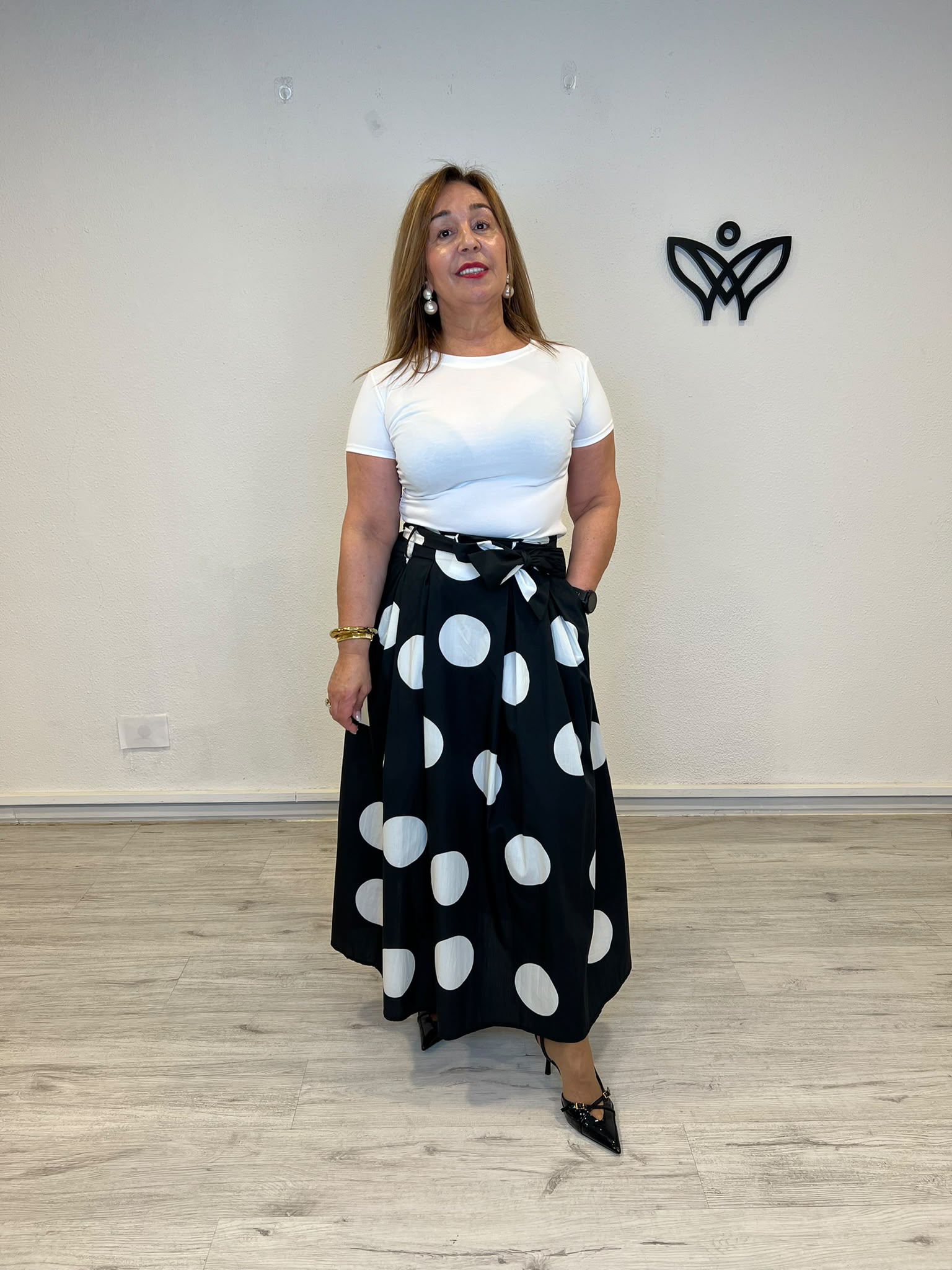 Falda negra con lunares blancos y bolsillos corte midi