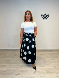 Falda negra con lunares blancos y bolsillos corte midi