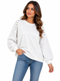 Sudadera de mujer blanca con cuello redondo y tachuelas doradas